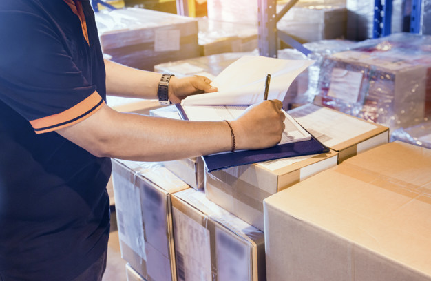 Employee filling in transport documents in a warehouse - freight logistics
